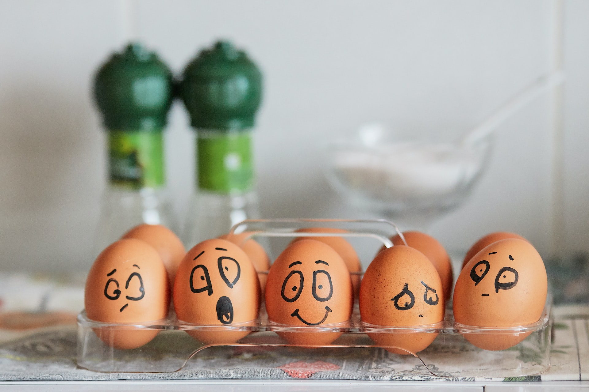 eggs in a box with different faces drawn on them
