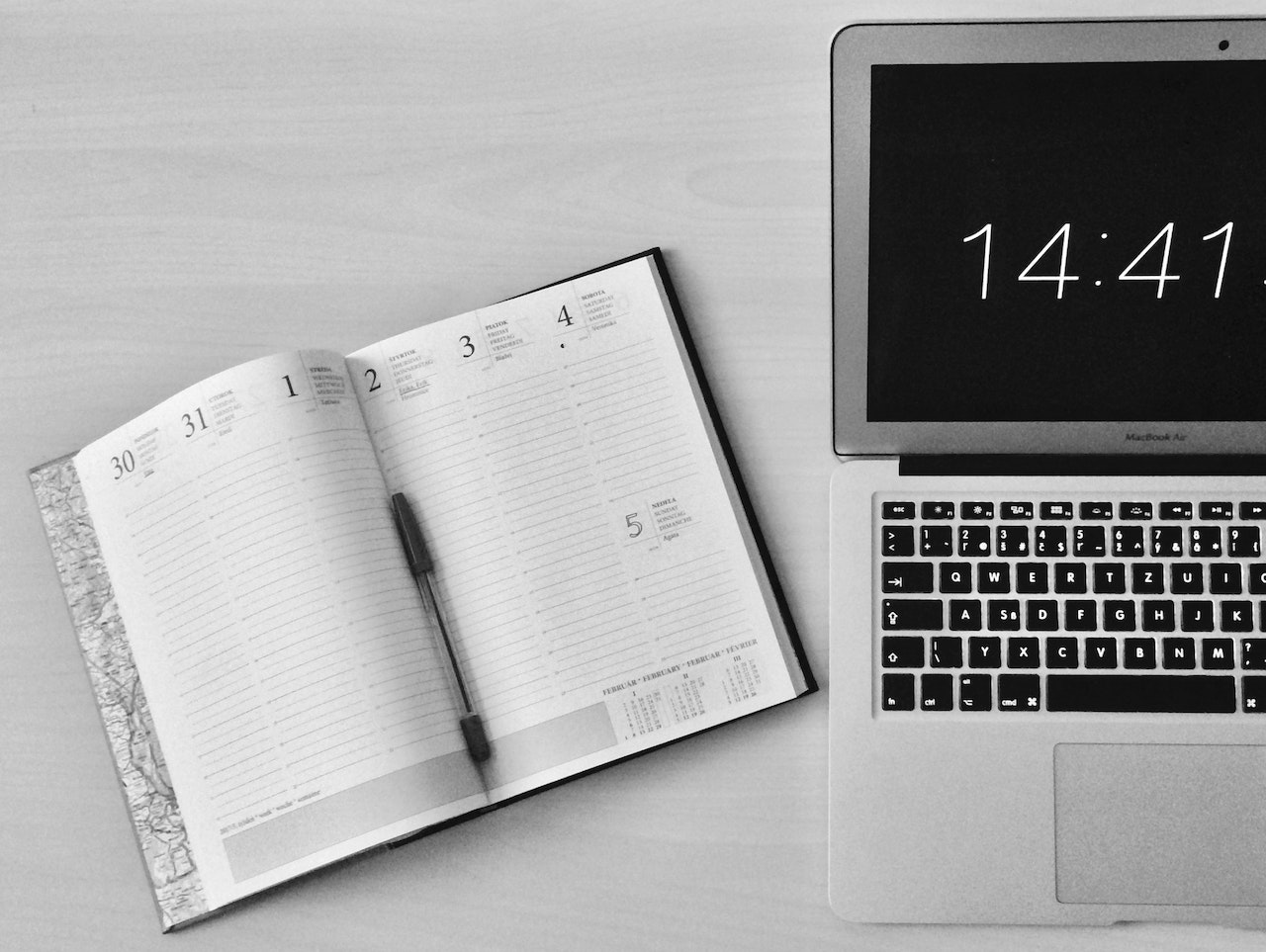 diary and laptop with the time on its screen