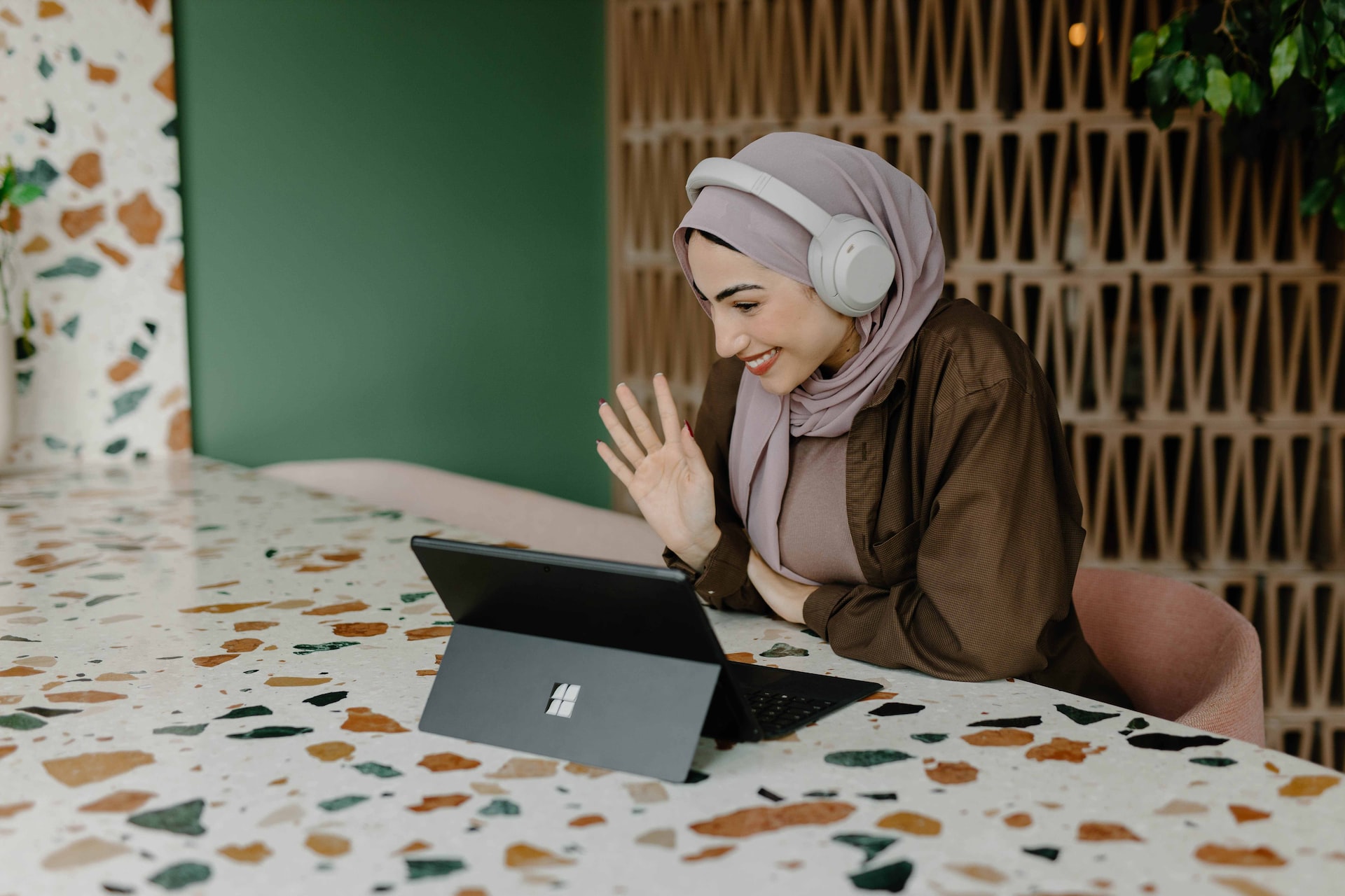 woman waving to laptop screen